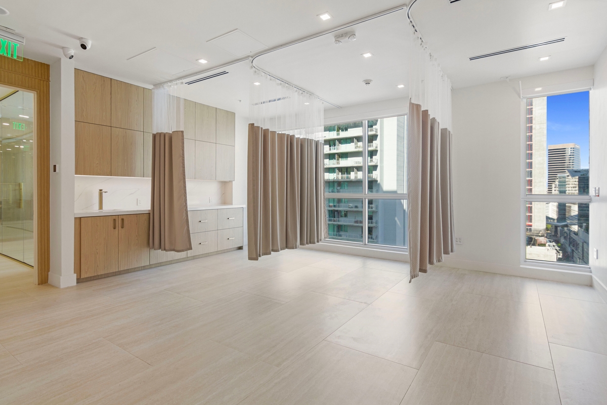 Three-bed recovery area with privacy curtains, cabinetry and floor-to-ceiling windows